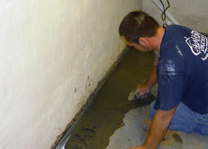 Restoring a concrete slab floor with fresh concrete after jackhammering it and installing a drain system in Ponoka.
